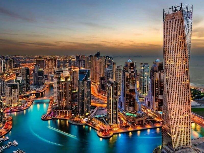 Khung cảnh đêm lộng lẫy của trung tâm thành phố Dubai, nổi bật với ánh sáng từ các cao ốc và hoạt động kinh doanh sầm uất.