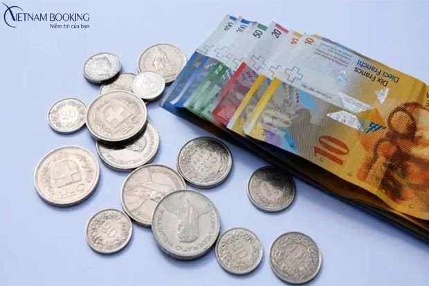Đồng franc Thụy Sĩ và máy tính, tượng trưng cho chi phí định cư Thụy Sĩ