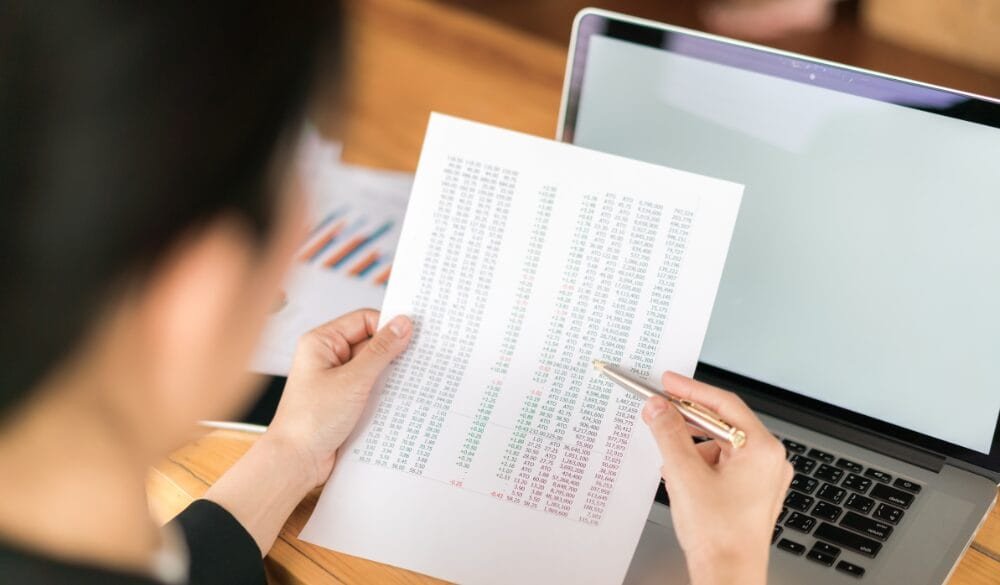 Một gia đình đang xem xét các giấy tờ và biểu đồ tài chính, tượng trưng cho việc chuẩn bị kỹ lưỡng về tài chính để định cư Canada