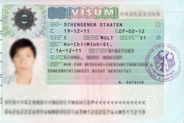 Một người phụ nữ trẻ đang làm việc với máy tính và tài liệu, tượng trưng cho quá trình chuẩn bị hồ sơ visa định cư Đức một cách cẩn trọng.