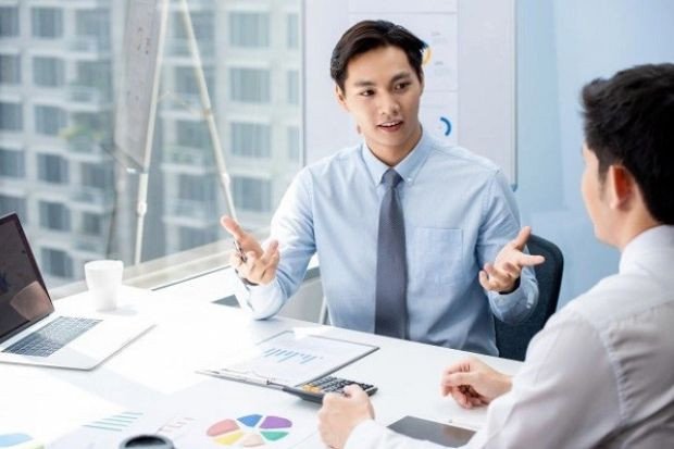 Hai người đang trao đổi công việc trong văn phòng, thể hiện vai trò của người đại diện trong việc hỗ trợ đầu tư kinh doanh tại Nhật Bản.