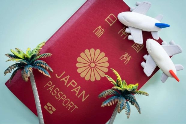 Một chồng tài liệu và giấy tờ liên quan đến hồ sơ xin visa đầu tư định cư Nhật Bản, đặt trên bàn làm việc.