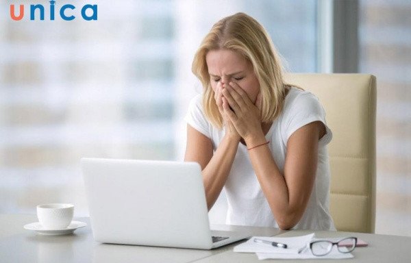 Một người phụ nữ trẻ đang nhảy mũi, hình ảnh tập trung vào cảm giác khó chịu của việc hắt hơi