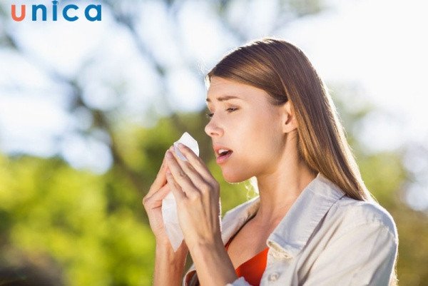 Người đàn ông đang hắt xì hơi, tay che mặt, tập trung vào điềm báo nhảy mũi